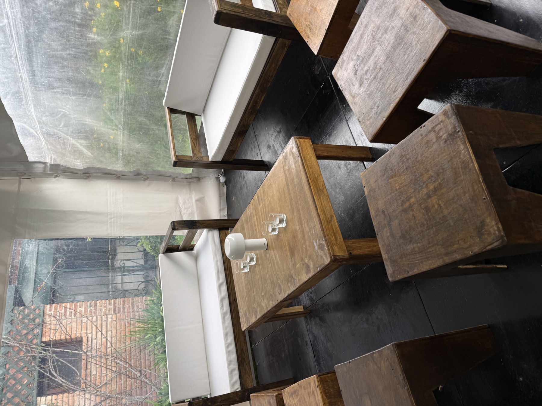 Living de madera con almohadones blancos dentro de carpa real
